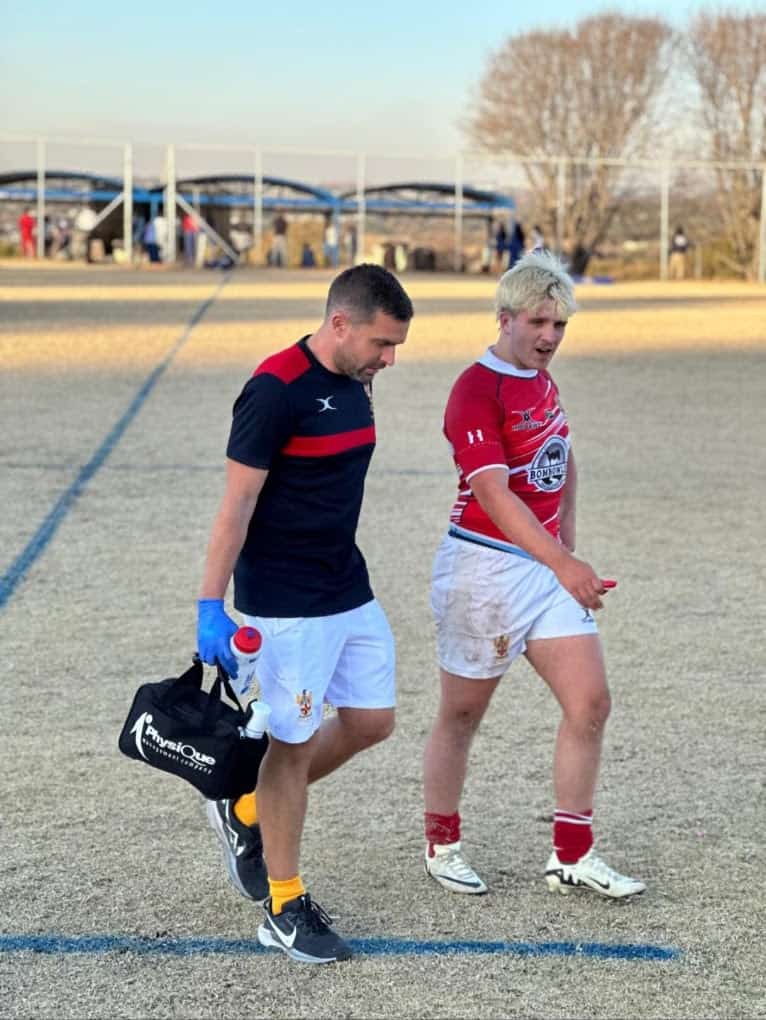 Fit Again Sports Therapy supporting an injured rugby player leaving the pitch